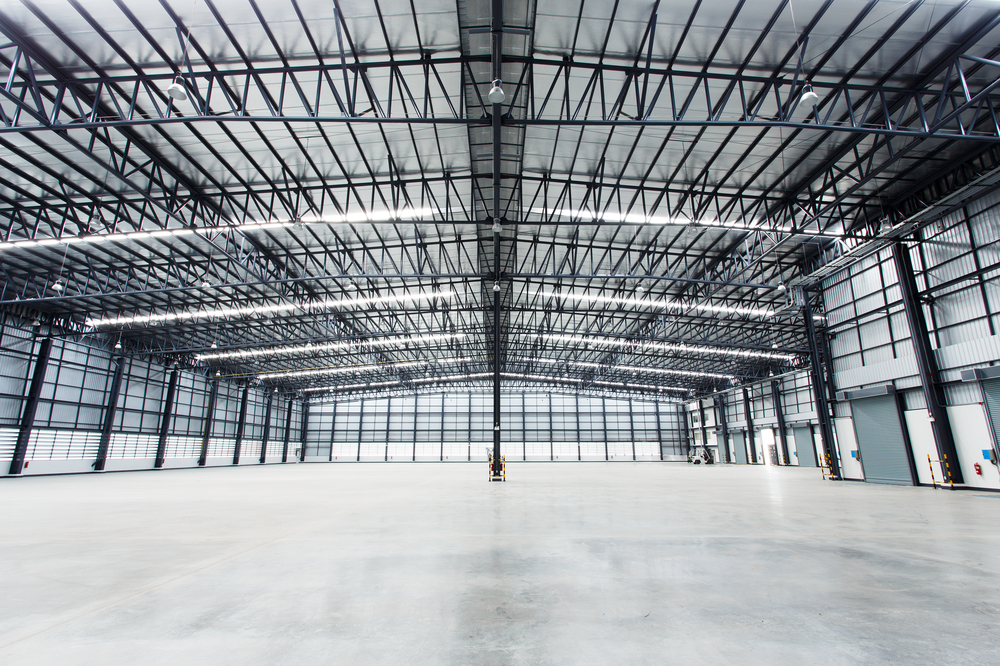Interior of a large steel-framed industrial building showing roof trusses